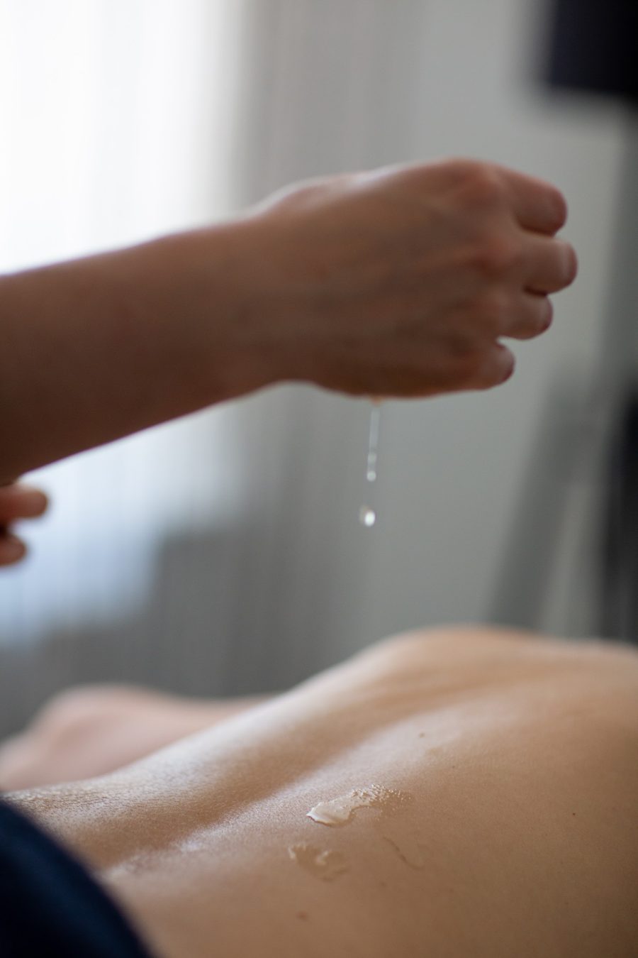 Warm massage oil being applied during a treatment